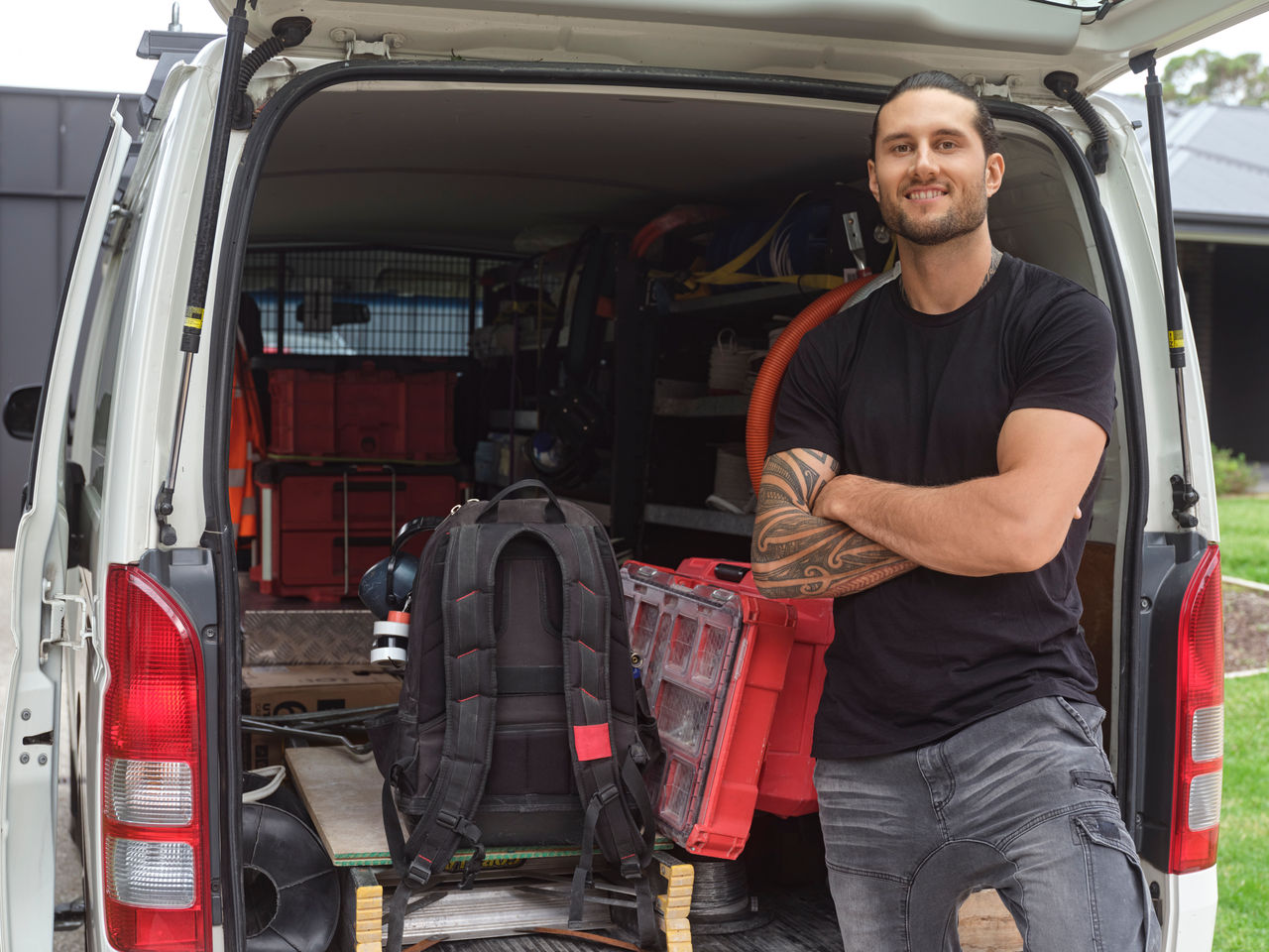 Tradesman standing in front of work van
